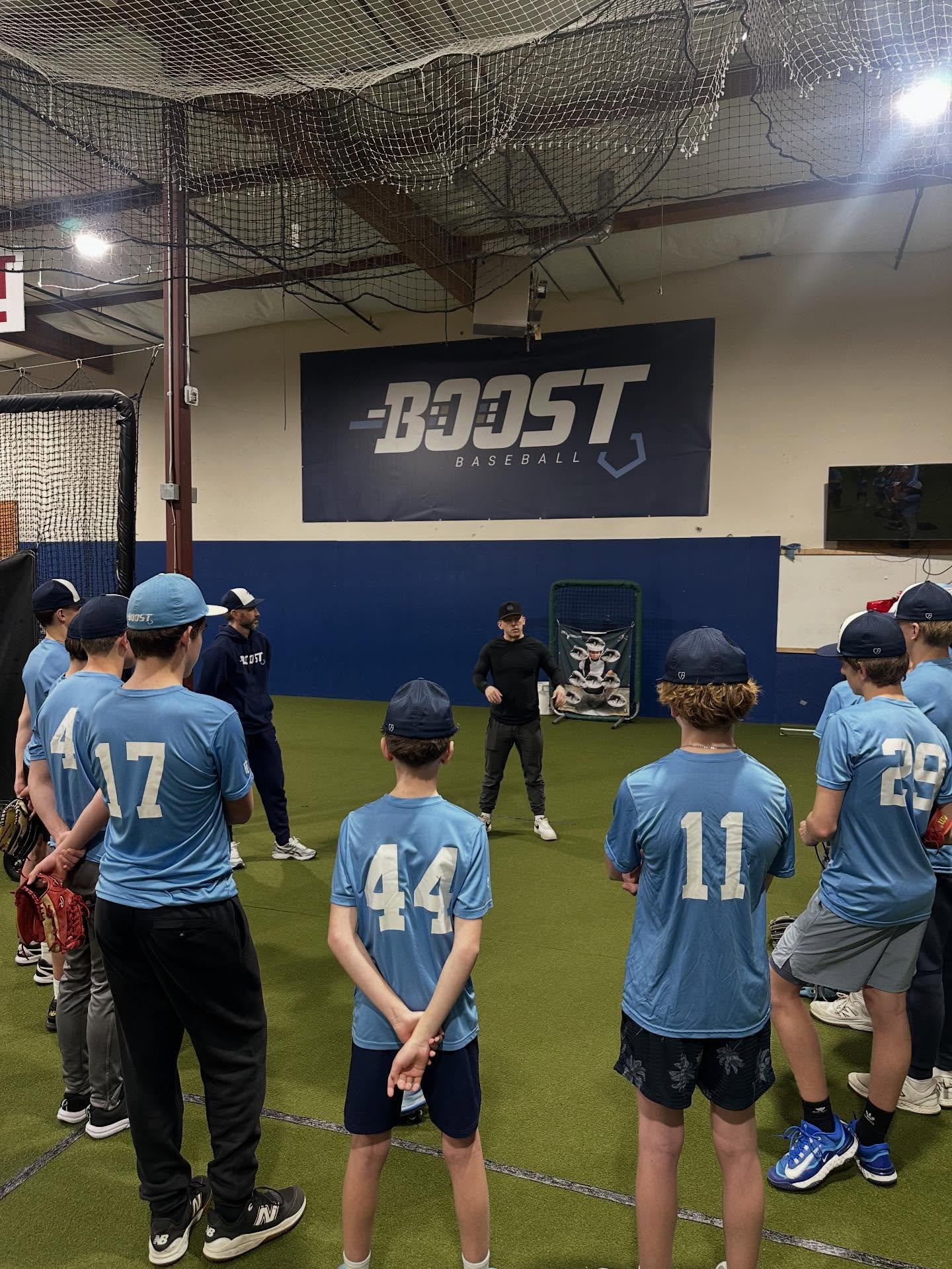 Young Boost teammates together — team energy in the dugout.
